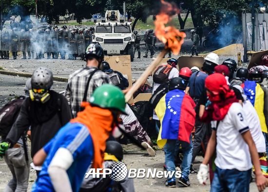 22일(현지시간) 베네수엘라 수도 카라카스에서 반정부 시위대가 대법원으로 행진하던 중 경찰과 대치하고 있다./AFPBBNews=뉴스1