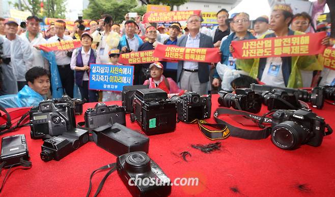 내려놓은 카메라… 삭발한 머리카락 - 한국프로사진협회원 1000여명이 28일 오후 서울 광화문 세종로공원에서 정부의 ‘블라인드 채용’ 정책에 반대하는 집회를 열고 있다. 이들은 “공공기관 이력서에 사진을 못 붙이게 하는 정책이 여권·증명사진 위주로 영업하는 동네 사진관의 생존을 위협한다”고 주장했다. /성형주 기자