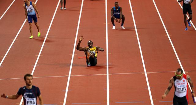 우사인 볼트(가운데)가 13일 런던 세계선수권 남자 400m 계주 결선에서 마지막 주자로 나서 허벅지 부상으로 쓰러져 있다. 런던=EPA 연합뉴스