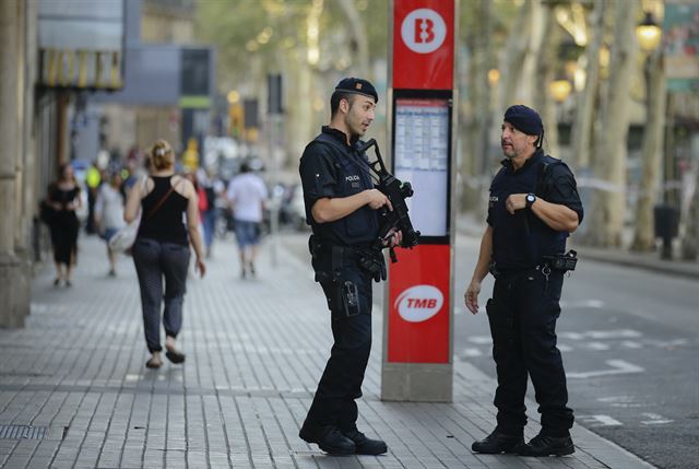 스페인 바르셀로나 람블라스거리에서 차량 돌진 테러가 발생한 다음날인 18일 무장 경찰들이 추가 공격에 대비해 치안 활동을 펼치고 있다. AP 연합뉴스