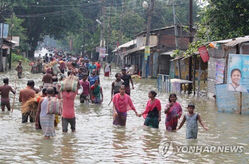 17일 인도 동부 웨스트벵골 주 발루가트에서 주민들이 침수된 도로를 걷고 있다.[AFP=연합뉴스 자료사진]