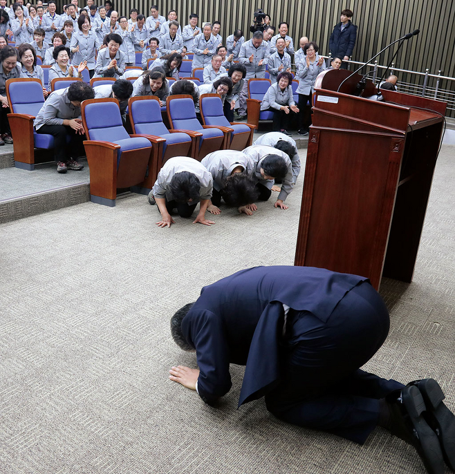 우윤근 국회 사무총장과 청소노동자들이 1월2일 서로 큰절을 하고 있다. © 사진=연합뉴스