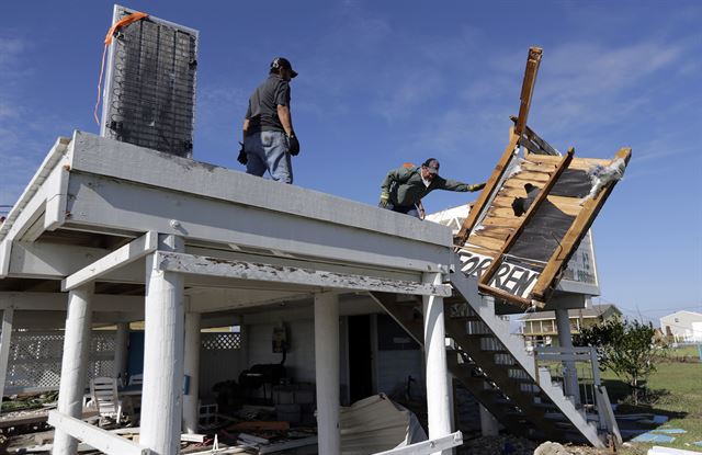 허리케인 하비로 피해를 입은 미 텍사스주 록포트에서 29일(현지시간) 한 가족이 부서진 주택의 잔해를 치우며 수습작업을 하고 있다. AP 연합뉴스