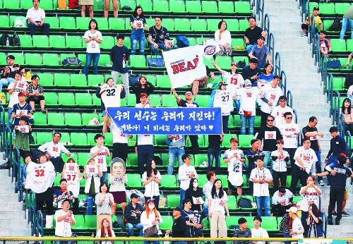 서울 잠실구장에서 30일 열린 두산 베어스와 롯데 자이언츠와의 경기에서 두산 팬들이 좌익수 뒤 외야석에서 김재환의 등 번호를 달고 그를 응원하는 플래카드를 내걸고 있다. 뉴시스
