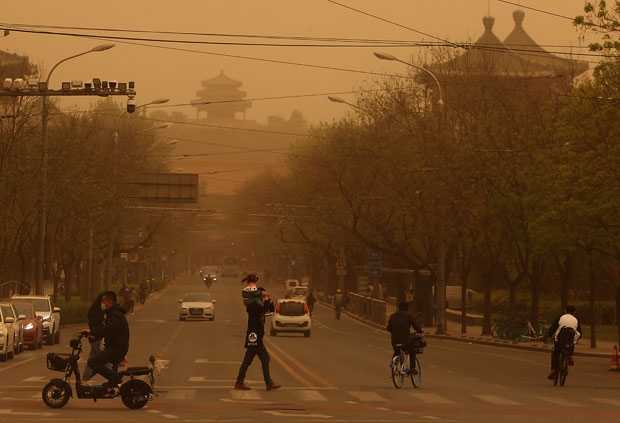 하늘이 누렇게 뒤덮인 베이징에서 행인들이 옷깃을 여미며 길을 건너고 있다. UPI 연합뉴스