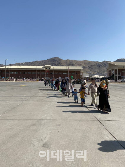 24일 아프가니스탄 카불공항에서 한국행을 위한 비행기로 이동하는 아프간 현지인들의 모습. (사진= 외교부 제공)