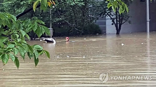 (부산=연합뉴스) 11일 집중호우가 내린 부산시 수영구 망미초등학교 인근에서 차량 1대가 물에 잠겨 119구조대원이 현장 수색을 벌이고 있다. 2017.9.11 [독자 이사랑·이상목 제공=연합뉴스]      pitbull@yna.co.kr