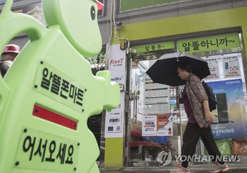 (서울=연합뉴스) 윤동진 기자 = 서울의 한 알뜰폰 매장 앞을 한 시민이 걸어 가고 있다. 2017.9.6      mon@yna.co.kr