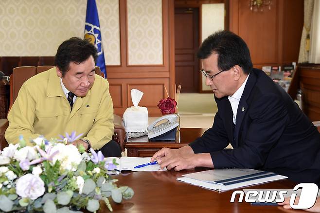 이낙연 국무총리(왼쪽)가 이시종 충북지사로부터 지역 현안에 대해 설명을 듣고 있다.  © News1