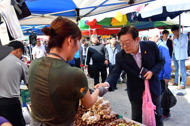 이재명 성남시장이 지난달 29일 성남 모란5일장을 방문해 성남사랑상품권으로 물건을 사고있다.