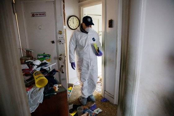 조지 벨 소유의 아파트를 둘러보며 시신의 신원을 확인하기 위해 노력하는 검시관. [사진 뉴욕타임스]