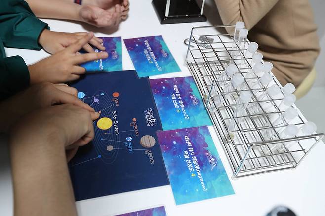 모델들이 '대우주'에 등장하는 우주선 분위기로 만든 방에서 탈출 게임을 하고 있다. 신인섭 기자