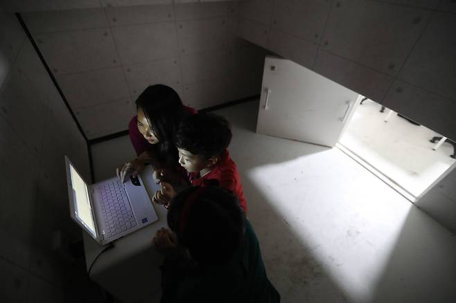 우주선 분위기로 만든 방에서 탈출 게임을 하면서 노트북을 이용해 힌트를 찾고 있다. 신인섭 기자