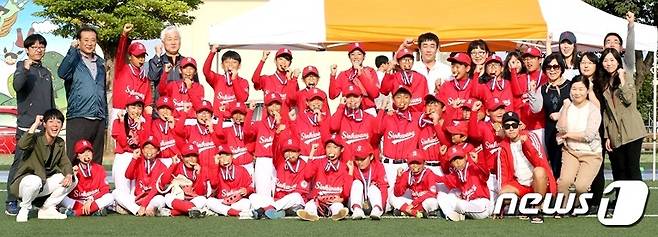 제주도교육감배 전도학교스포츠클럽 티볼종목에서 우승을 차지한 신광초등학교 티볼부가 기념사진을 찍고 있다.  가장 아랫줄 왼쪽 끝에서 화이팅을 외치고 있는 남성이 티볼부를 이끌고 있는 김민기 교사다. 2017.10.17/뉴스1 © News1