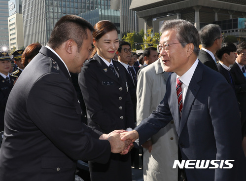 문재인 대통령이 20일 서울 광화문광장에서 열린 경찰의날 기념식에 참석해 배우 마동석과 인사를 하고 있다. 뉴시스