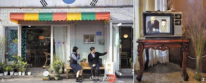 1 망원동 카페 ‘우아하게’에서 곳곳에 놓인 80~90년대 소품을 배경으로 사진 찍는 신세대 손님들. 2 브라운관 텔레비전에서 만화 ‘빨간머리 앤’이 흘러나오는 망원동 ‘오늘의 위로’./이신영 영상미디어 기자
