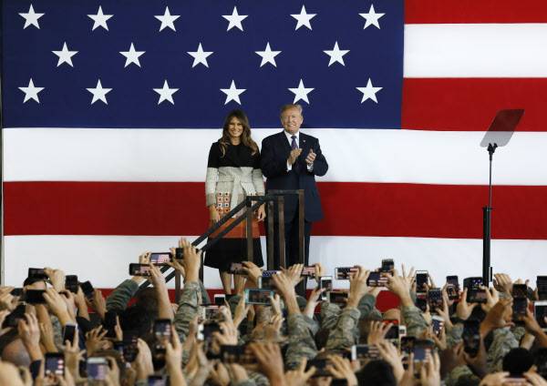 5일 일본 도쿄 인근 요코타 공군기지 격납고에서 도널드 트럼프 미국 대통령이 멜라니와 여사와 함께 연단에 선 모습. /연합뉴스·EPA