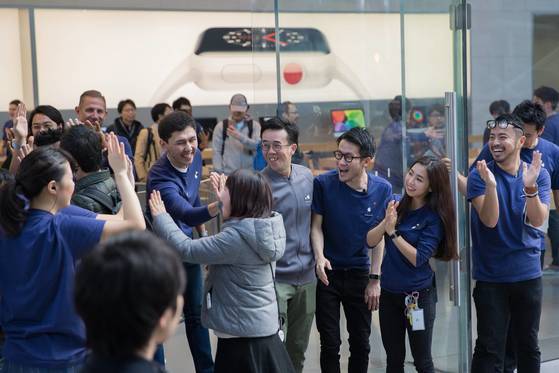 도쿄의 애플 매장에서 3일 오전 아이폰 X를 구입하려는 첫번째 고객이 매장안으로 들어서며 직원들과 하이파이브를 하고 있다. [epa=연합뉴스]