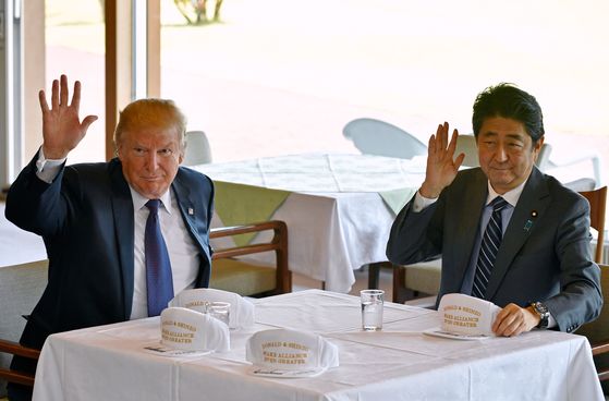도널드 트럼프 미국 대통령과 아베 신조 일본 총리가 5일 가스미가세키 컨트리클럽의 클럽하우스에서 취재진을 향해 손을 흔들고 있다.[AFP=연합뉴스]
