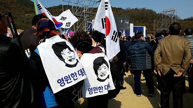 14일 오전 경북 구미 박정희 전 대통령 생가 주변에서 열린 ‘박정희 대통령 탄생 100돌 기념식’에서 일부 참가자들이 박근혜 전 대통령의 얼굴이 그려진 펼침막을 등에 붙여 다니고 있다.