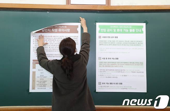 교육부가 포항에서 발생한 지진으로 인해 수능시험을 일주일 연기한 가운데 16일 오전 대전시교육청 제27지구 제28시험장인 동방고등학교에서 학교 관계자가 시험장 내 수험생 유의사항이 적힌 표지판을 제거 하고 있다. 2017.11.16/뉴스1 © News1 주기철 기자