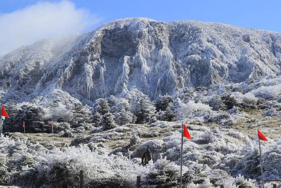 19일 제주도 한라산에 올해들어 첫 눈이 내렸다. 지난해 보단 18일 늦었다. 관광객이 한라산 영실 코스를 오르고 있다. [연합뉴스]