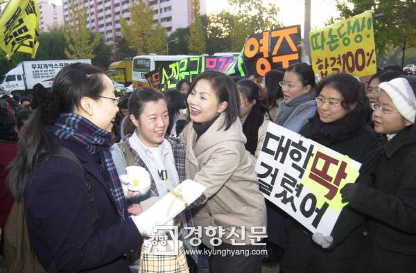 2001년 11월 7일 2002학년도 대학수학능력시험 고사장인 서울 경기여고 교문에서 교사와 후배들이 합격을 기원하는 플래카드와 피켓 등을 든 채 시험장에 들어가는 수험생들을 격려하고 있다. 경향신문 자료사진