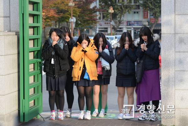 2015학년도 대학수학능력시험이 치러진 2014년 11월 13일 서울 중구 이화여자외국어고등학교 앞에서 풍문여고 학생들이 수능 응원 전통에 따라 시험을 치르는 선배들을 향해 기도를 하고 있다. 이어 교문을 향해 절을 올렸다. 강윤중 기자