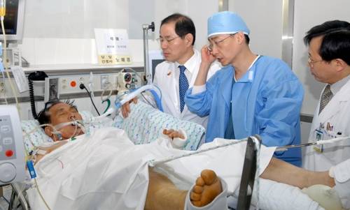 2011년 1월 31일 이국종 교수 등 전담 의료진이 경기도 수원 아주대병원 중환자실에서 전날 1차 수술을 마친 석해균 삼호주얼리호 선장을 회진하며 수술 상처 부위가 잘 치유되고 있는지 확인하는 모습. [아주대병원 제공]