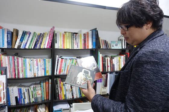 가정에서 손쉽게 따뜻한 차를 만들어 마시고 싶은 사람에게 책을 추천해 달라고 하자 『나의 핫드링크 노트』라는 책을 권하며 일본어 원서와 한글 번역본을 보여주고 있다.