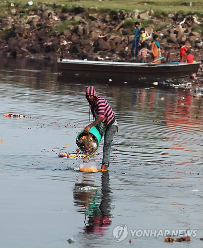 2014년 3월 인도 뉴델리 외곽 야무나 강에서 한 주민이 쓰레기를 강물에 버리고 있다.[EPA=연합뉴스 자료사진]