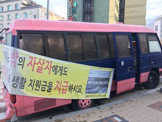 정선 일대에서 운행하는 도박예방 상담센터 차량.차량에 붙은 플래카드는 자살자를 포함한 도박 피해자 가족들이 강원랜드에 위자료 등의 배상을 요구하는 내용이다. 하준호 기자