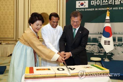 스리랑카 대통령 위한 국빈만찬 (서울=연합뉴스) 문재인 대통령이 29일 청와대에서 열린 마이트리팔라 시리세나 스리랑카 대통령을 위한 국빈만찬에서 축하떡을 자르고 있다. [청와대제공=연합뉴스]      photo@yna.co.kr