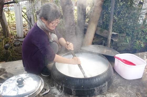 비지를 걸러낸 콩즙을 끓이는 동안 바닥이 눌지 않도록 나무주걱으로 계속 젓고 있는 안보경씨. 안씨는 추두부·꿩두부 재현 작업에 참여하기 위해 경기도 안산에서 오전 5시에 출발해 충북 옥천에 왔다고 한다.
