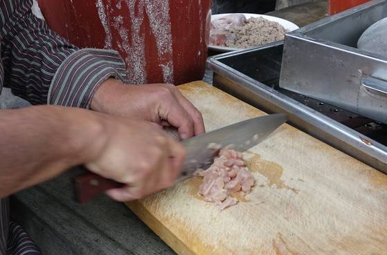 꿩두부에 들어갈 꿩고기를 잘게 썰고 있다.