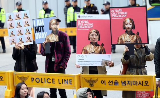 지난 10월 25일 오후 서울 종로구 주한일본대사관 앞에서 한국정신대문제대책협의회(정대협) 주최로 열린 '일본군 성노예 문제 해결을 위한 정기 수요시위'에서 참가자들이 손피켓을 들고 있다. [연합뉴스]