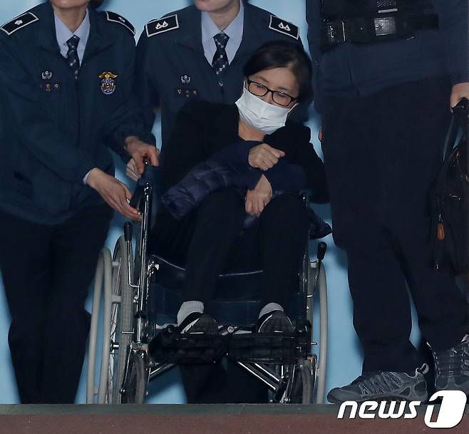 '비선실세' 최순실 씨가 14일 오후 서울 서초구 서울중앙지방법원에서 열린 직권남용권리행사방해 등 결심공판을 마친 뒤 휠체어를 타고 호송차로 향하고 있다. 2017.12.14/뉴스1 © News1 민경석 기자