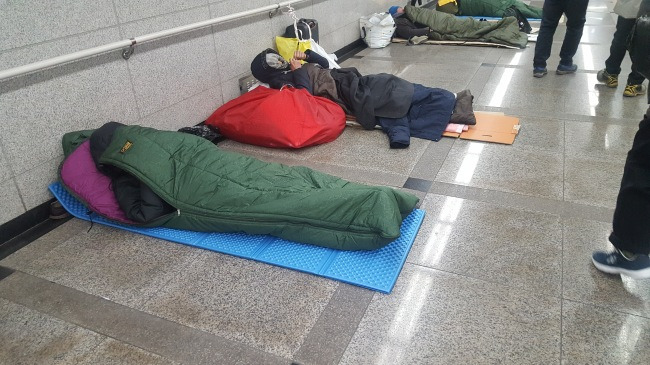 노숙인 한 무리가 지하철 서울역사안에 자리를 펴고 누워있다.