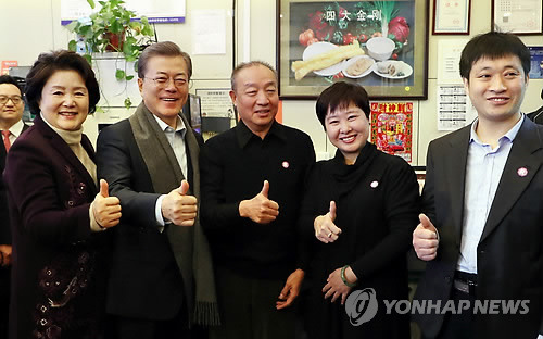 베이징 서민식당에서 기념촬영하는 문 대통령 내외 (베이징=연합뉴스) 배재만 기자 = 문재인 대통령과 부인 김정숙 여사가 14일 오전 중국 베이징 조어대 인근 한 현지 식당에서 중국인들이 즐겨 먹는 아침 메뉴인 만두(샤오롱바오), 만둣국(훈둔), 꽈배기(요우티아오), 두유(도우지앙)을 주문해 식사를 한 후 식당 관계자들과 기념 촬영을 하고 있다.    scoop@yna.co.kr