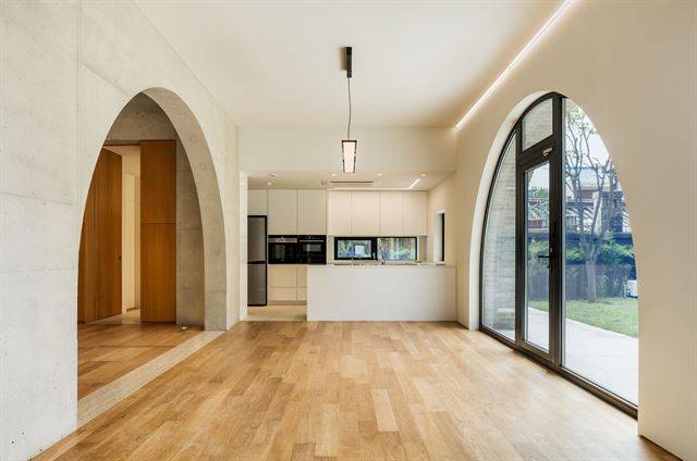 마당을 향해 난 아치형 창문과 식당과 거실을 나누는 콘크리트 아치. 신경섭 건축사진작가 제공