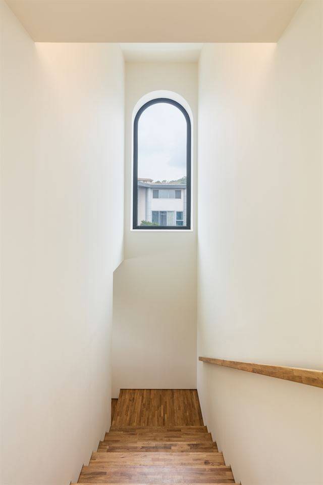 3층 계단실의아치형 창문. 집을 둘러보고 내려오는 이들에게 선물하는 마지막 하이라이트 장면이다. 신경섭 건축사진작가 제공