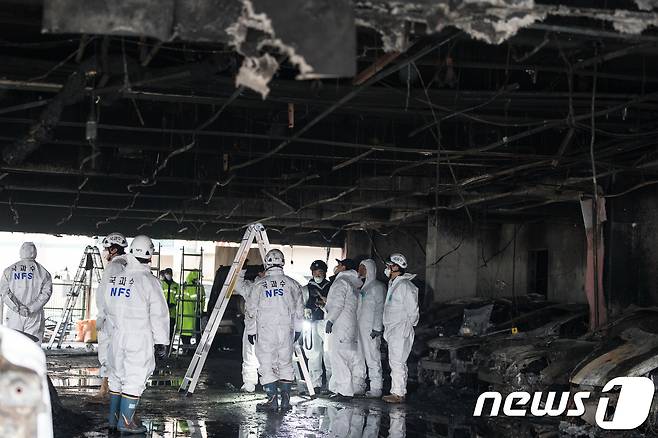 국립과학수사연구원 직원들과 경찰 과학수사대가 24일 제천 스포츠센터 화재 현장 1층 주차장 발화지점 부근에서 현장 감식을 하고 있다. 2017.12.24/뉴스1 © News1 유승관 기자