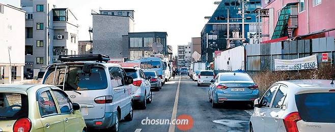처참한 현장이 앞에 보이는데도… - 25일 충북 제천 하소동 스포츠센터(오른쪽 검게 그을린 건물) 인근 왕복 2차선 도로 양편에 불법 주차한 차들이 늘어서 있다. 희생이 컸던 이유 중 하나는 불법 주차로 소방차 진입이 늦어졌기 때문이다. 당시 소방차들은 사진의 왼쪽에서 오른쪽으로 나 있는 도로를 따라 화재 현장에 접근하려 했으나 불법 주차 때문에 실패했다. 사진 속 도로를 이용해 우회할 수 있었으나, 이 역시 불법 주차 때문에 큰길로 나가 500m나 돌아가야 했다. /남강호 기자