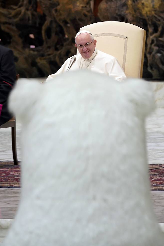 프란치스코 교황이 27일(현지시간) 바티칸의 바오로 6세 알현실에서 공연을 펼치고 있는 서커스단의 대형 인형 북극곰에게 미소를 지어보이고 있다. [AP=연합뉴스]