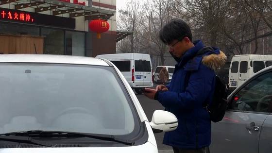 베이징시 300여 곳에 위치한 공유 전기 자동차 업체 이두융처의 자동차를 휴대폰 앱을 이용해 문을 열고 있다. [사진=선르주 JTBC 촬영기자]