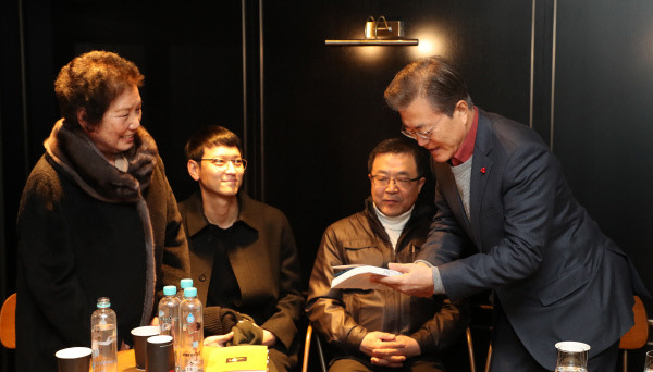 문재인 대통령이 7일 오전 서울 CGV 용산점에서 영화 ‘1987’을 관람하기 앞서 고 이한열 열사 모친 배은심 여사로부터 책 ‘1987 이한열’을 건네받고 있다. 청와대사진기자단