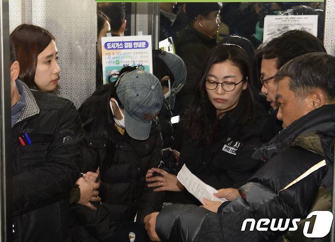 광주 아파트 화재로 아이 3명을 숨지게 한 혐의를 받고 있는 친모 A씨(22·여)가 3일 오후 화재가 발생했던 아파트에서 현장검증을 하기 위해 엘레베이터에 타 경찰의 고지를 받고 있다.2018.1.3/뉴스1 © News1 남성진 기자