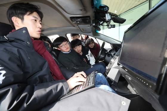 방학을 맞은 중학생들이 4일 서울 한양대 서울캠퍼스 미래자동차공학관을 찾아 학과에 대한 설명을 들었다. 이 대학 이성진(왼쪽·한양대 미래자동차공학과 박사과정) 연구원이 자율주행차에 탑승한 중학생들에게 프로그램 원리를 설명하고 있다. 김상선 기자