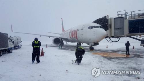 제주공항 계류장 제설작업 (제주=연합뉴스) 김호천 기자 = 11일 오전 제주국제공항 계류장에서 공항공사와 항공사 직원들이 제설작업을 벌이고 있다. 2018.1.11 [독자 제공=연합뉴스]      khc@yna.co.kr