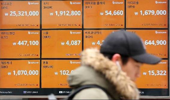 한 젊은 시민이 서울 중구 가상화폐 거래소 앞에 설치된 시세 전광판 앞을 지나가고 있다. / 조선DB
